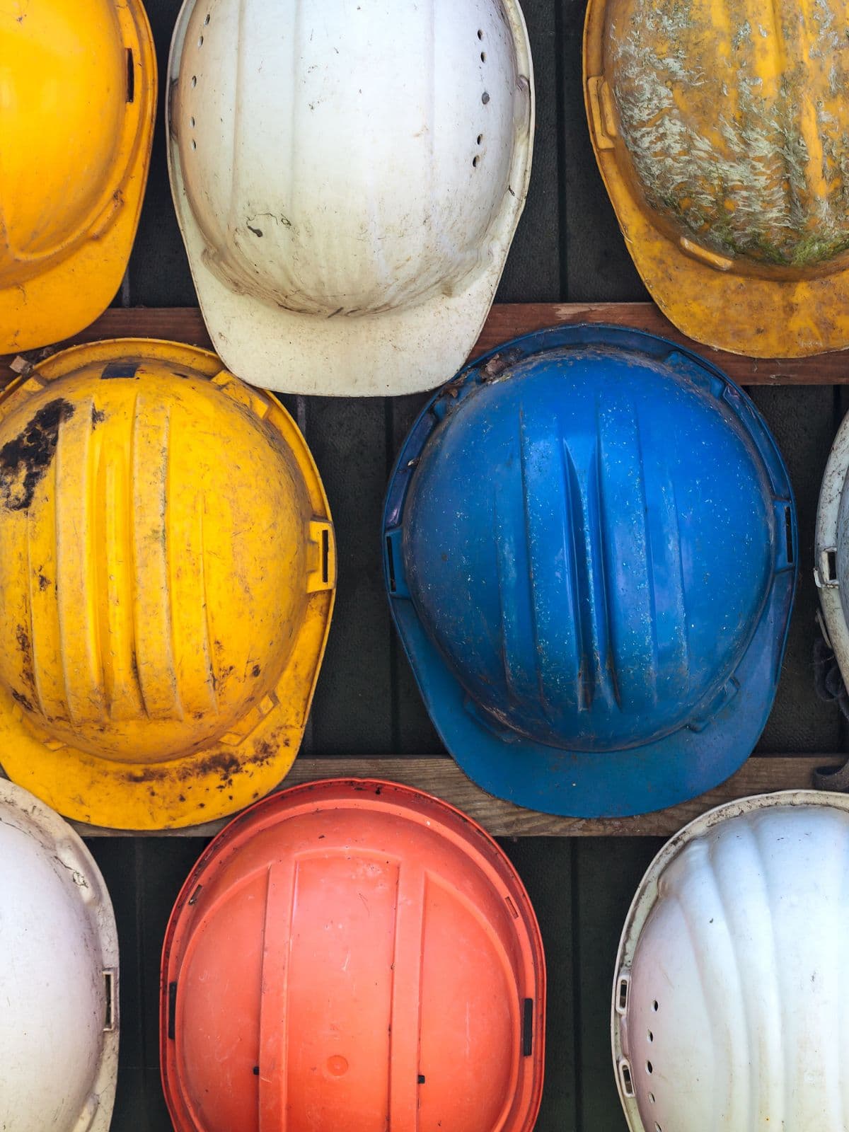 Colourful hard hats on a construction site rack